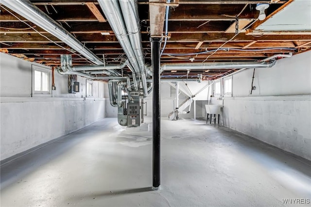 basement featuring heating unit and a sink