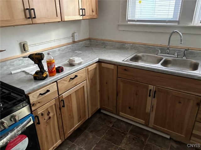 kitchen with gas stove, light countertops, and a sink