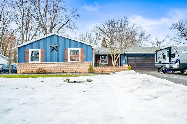 view of front facade featuring brick siding, a garage, and driveway