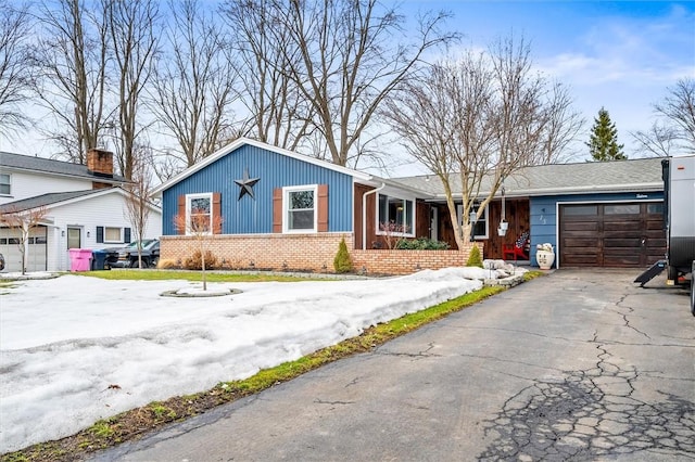 view of front of house featuring brick siding, driveway, and a garage