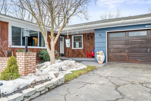 ranch-style house featuring aphalt driveway and a garage