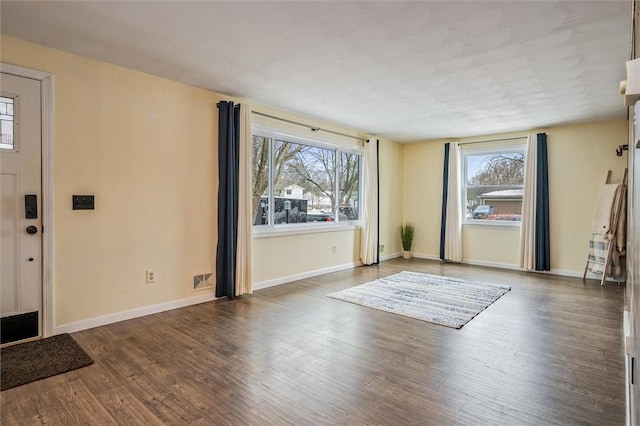 foyer with baseboards and wood finished floors