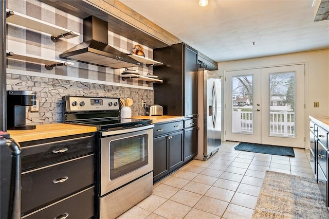 kitchen with open shelves, wall chimney range hood, butcher block countertops, and stainless steel appliances