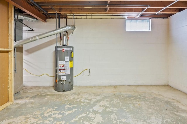 below grade area featuring water heater and concrete block wall