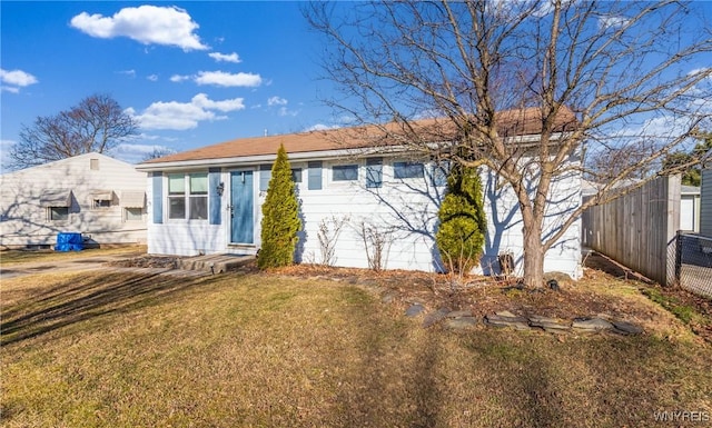 back of property featuring a lawn and fence