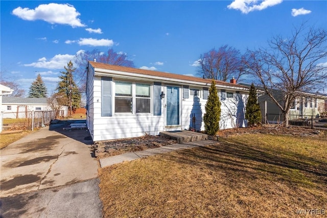 view of front of house featuring driveway, a front lawn, and fence