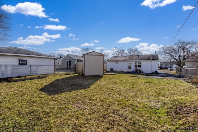 back of property featuring a storage unit, a yard, an outdoor structure, and fence