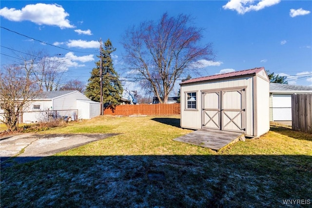 view of yard with a storage shed, a fenced backyard, and an outdoor structure