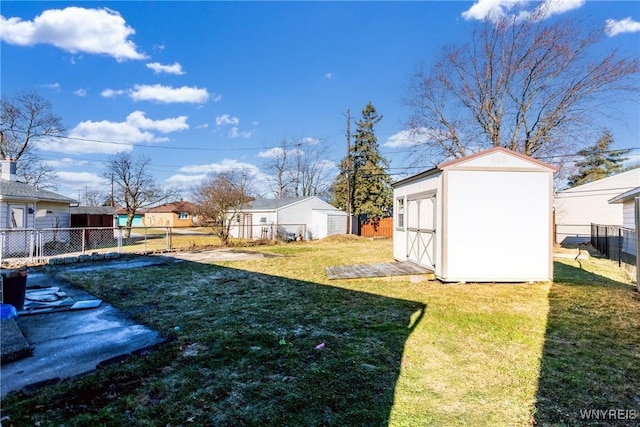 view of yard featuring an outdoor structure, a storage unit, and fence