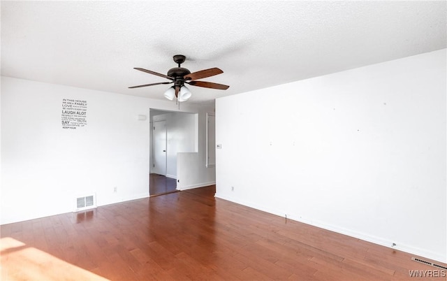 spare room with visible vents, a textured ceiling, wood finished floors, and a ceiling fan