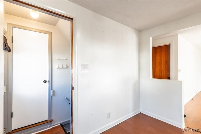 unfurnished room with baseboards and dark wood-style flooring