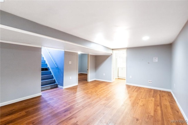 finished basement featuring stairway, baseboards, and wood finished floors