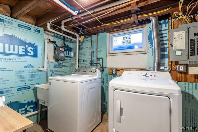 clothes washing area with electric panel, laundry area, and washing machine and dryer