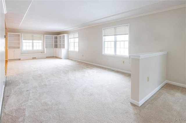 unfurnished room featuring baseboards, light colored carpet, and ornamental molding