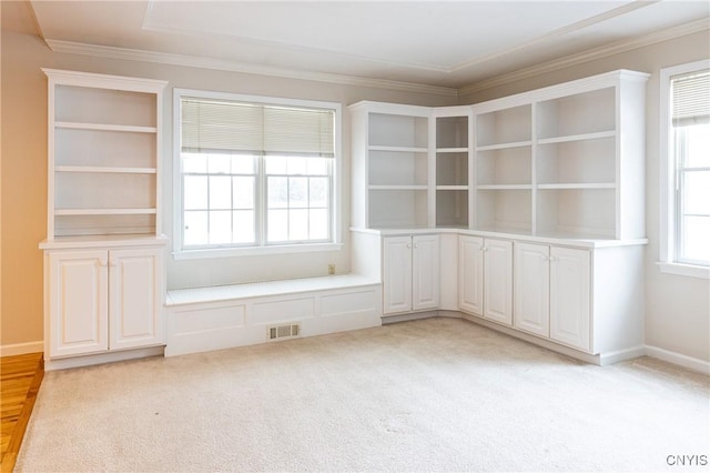 empty room with light carpet, visible vents, and ornamental molding