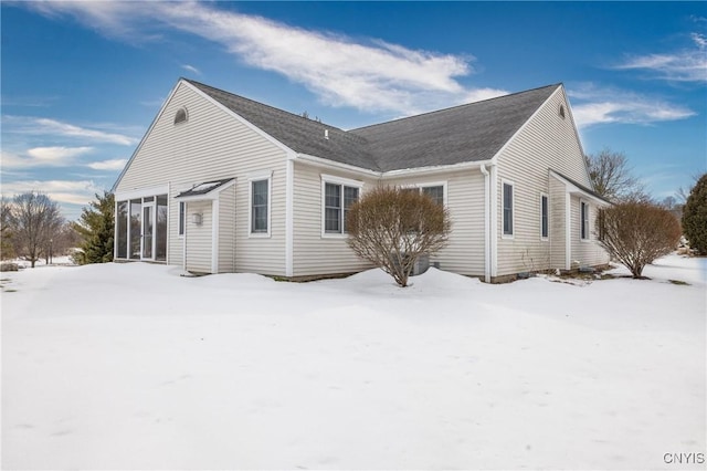 snow covered property with a sunroom