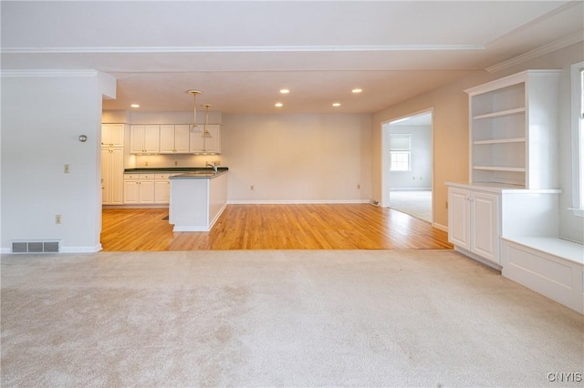 unfurnished living room featuring recessed lighting, visible vents, and light carpet