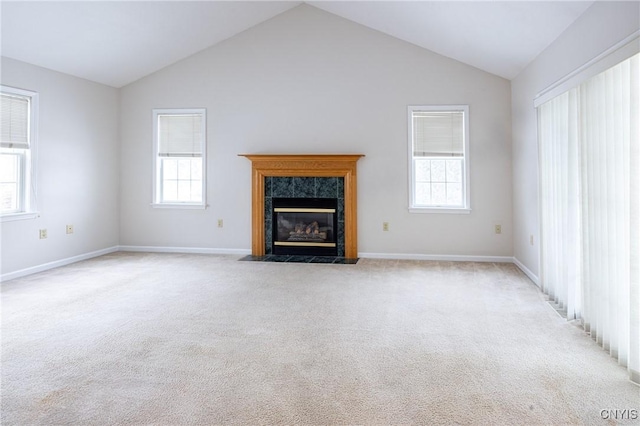 unfurnished living room featuring carpet flooring, plenty of natural light, and a high end fireplace