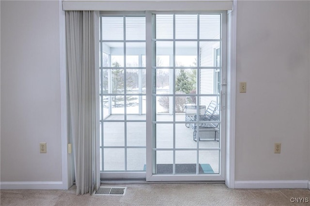 doorway featuring visible vents, baseboards, and carpet