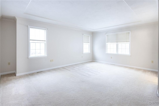 carpeted spare room featuring visible vents, a healthy amount of sunlight, baseboards, and ornamental molding