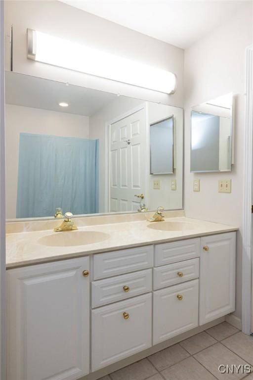 bathroom with a sink, double vanity, and tile patterned flooring