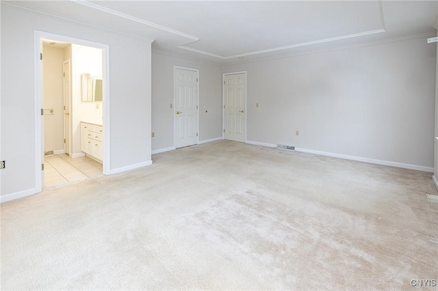 empty room featuring light carpet, baseboards, and ornamental molding