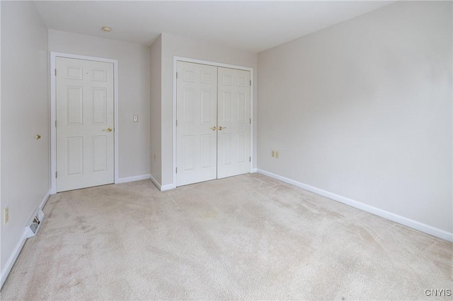 unfurnished bedroom with visible vents, baseboards, a closet, and carpet floors