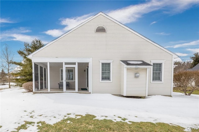 snow covered house with a sunroom