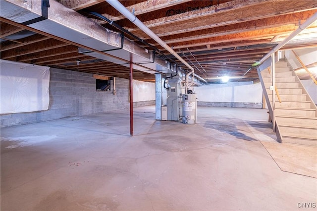 unfinished basement featuring water heater, stairway, and heating unit