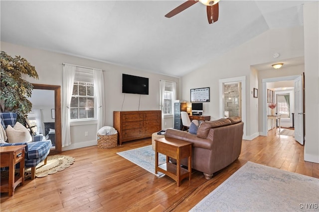 living room with light wood-style flooring, baseboards, lofted ceiling, and a ceiling fan