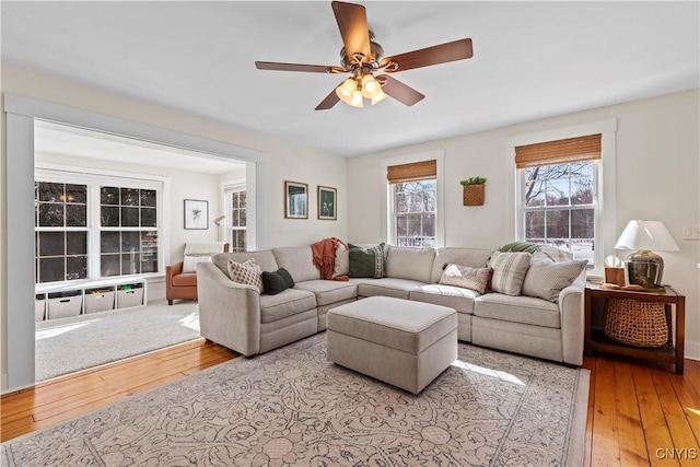 living area with light wood-style flooring and a ceiling fan