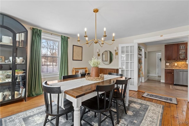 dining room featuring baseboards, light wood-style floors, and a chandelier