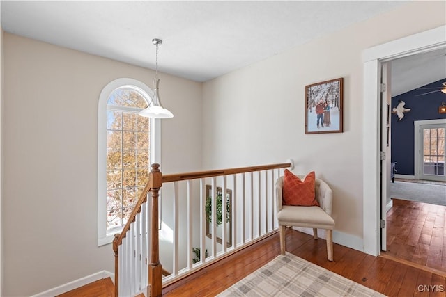 corridor with a wealth of natural light, baseboards, and hardwood / wood-style flooring