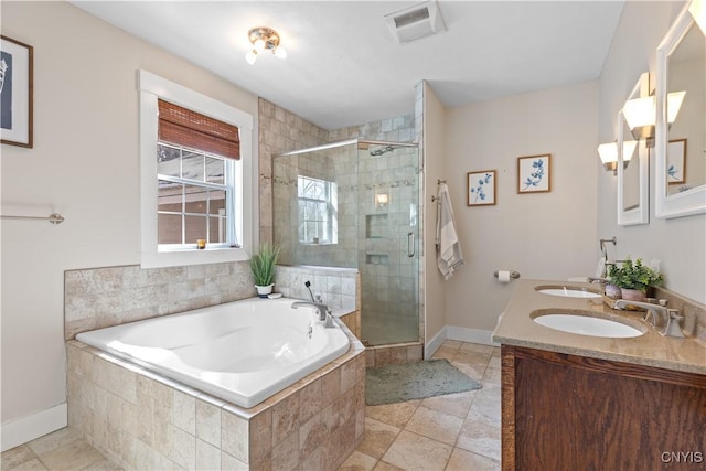 bathroom featuring visible vents, a shower stall, a garden tub, and a sink