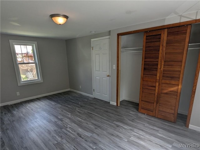 unfurnished bedroom with a closet, baseboards, and wood finished floors