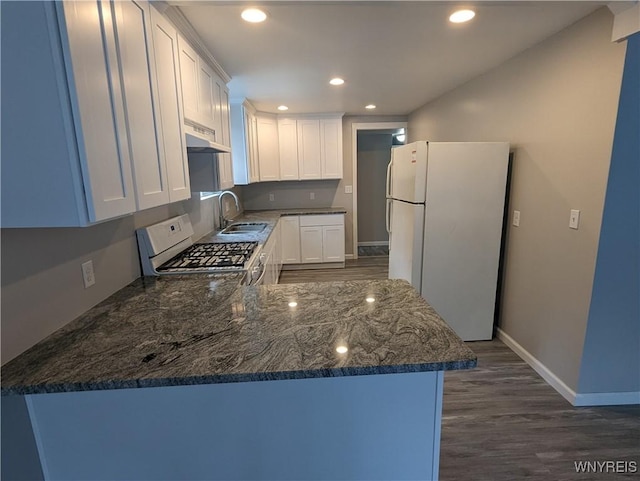 kitchen featuring under cabinet range hood, recessed lighting, white cabinets, white appliances, and a sink