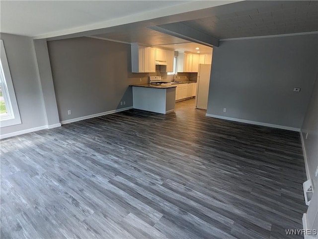 kitchen featuring range, baseboards, open floor plan, and freestanding refrigerator