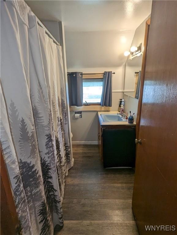 full bath featuring vanity, baseboards, and wood finished floors