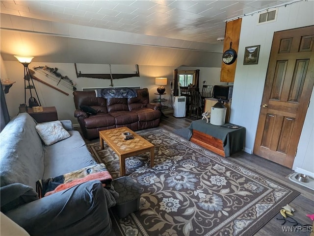 living area featuring visible vents, wood walls, and wood finished floors