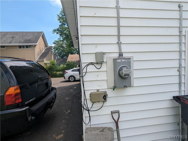 exterior details featuring electric meter and a parking lot