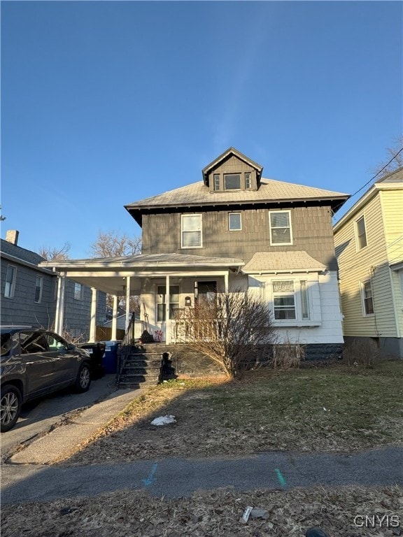 american foursquare style home with a carport and covered porch