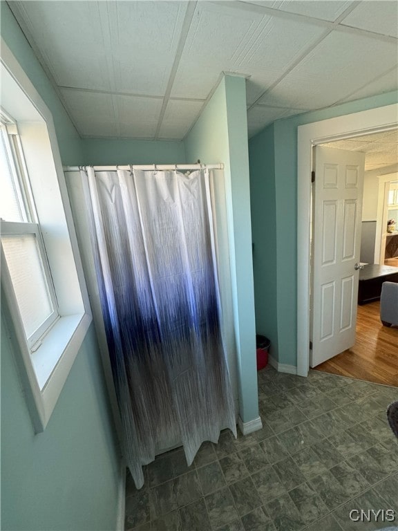 bathroom with a shower with shower curtain, baseboards, and plenty of natural light