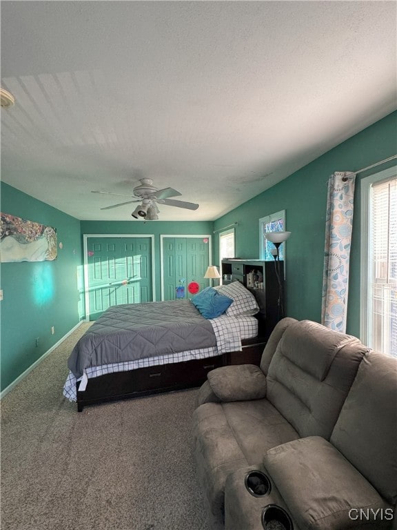 carpeted bedroom with a ceiling fan, baseboards, and a textured ceiling