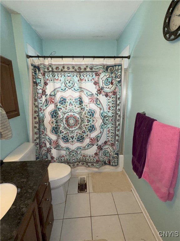 bathroom with tile patterned flooring, curtained shower, toilet, and vanity