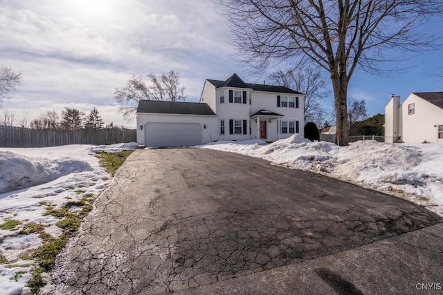 view of front of home with an attached garage, fence, and driveway