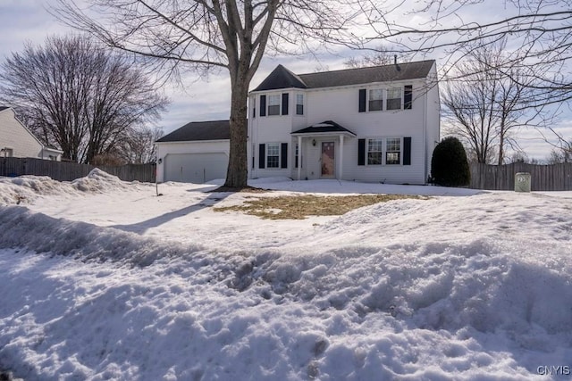 colonial house featuring a garage and fence