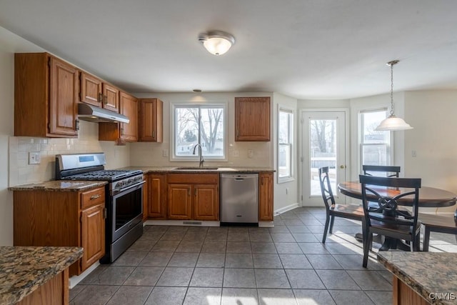 kitchen featuring a sink, brown cabinets, appliances with stainless steel finishes, and under cabinet range hood