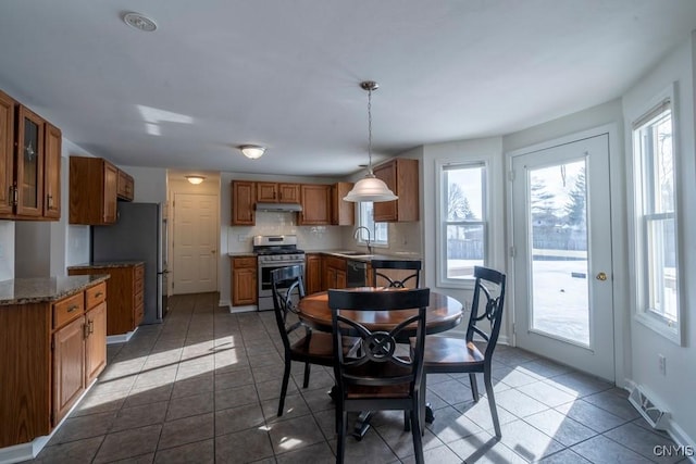 tiled dining area featuring baseboards, visible vents, and a sink