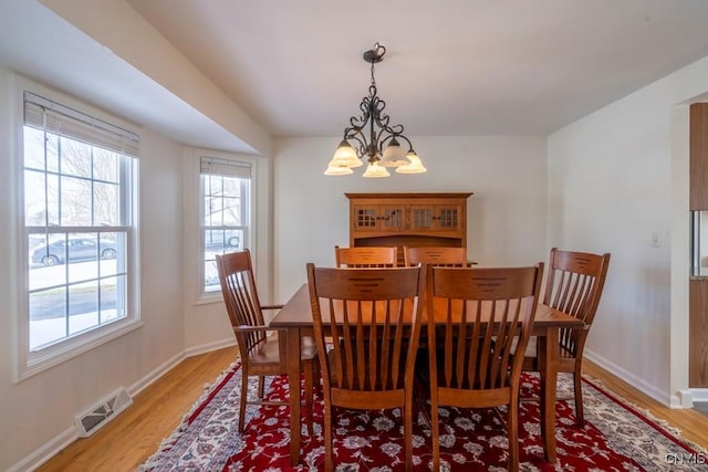 dining room featuring visible vents, baseboards, and light wood-style flooring