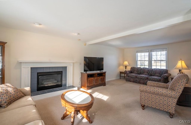 carpeted living room with beam ceiling and a tiled fireplace